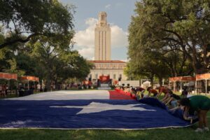 Texas flag unfurling in front of the UT Tower