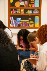 Close up photo of students writing with pencils on notepads