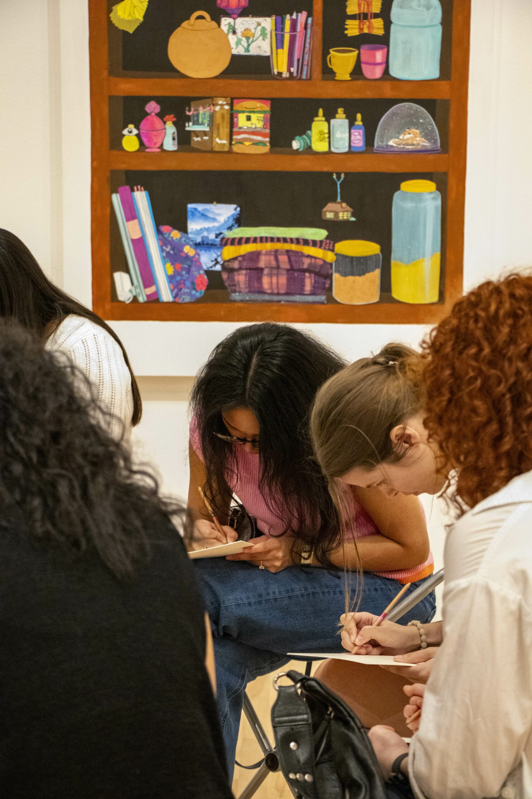 Close up photo of students writing with pencils on notepads