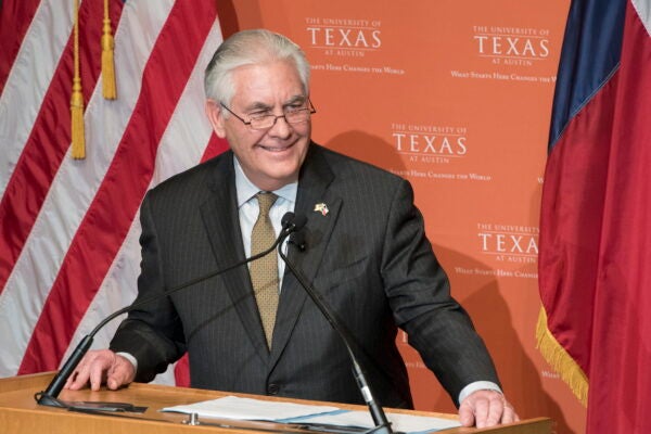 Rex Tillerson stands at podium