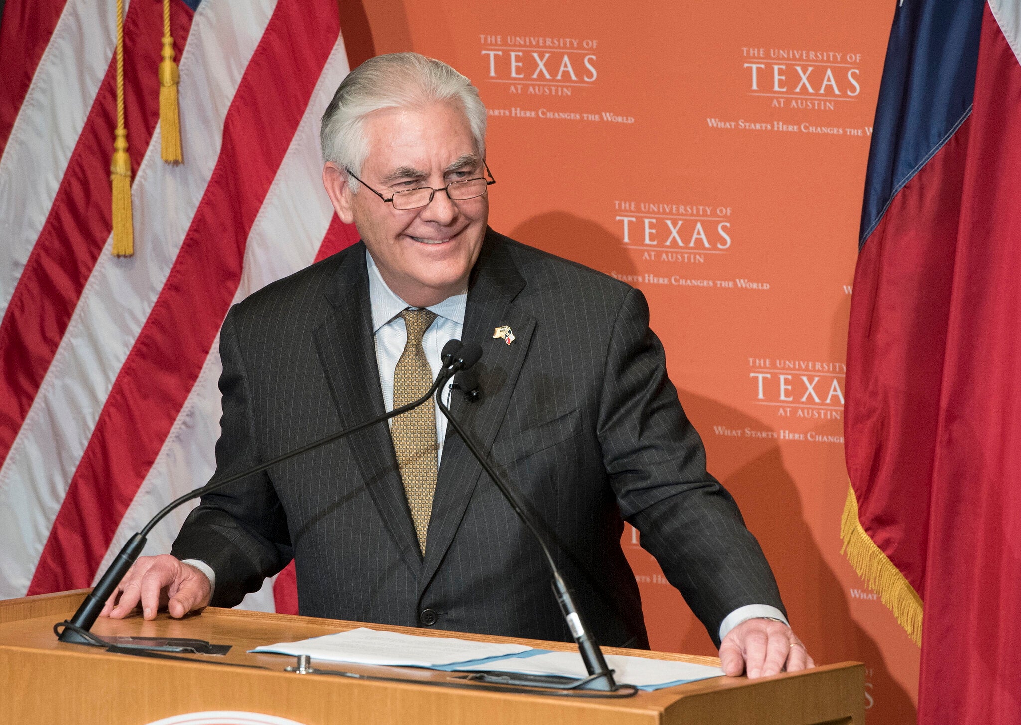 Rex Tillerson stands at podium