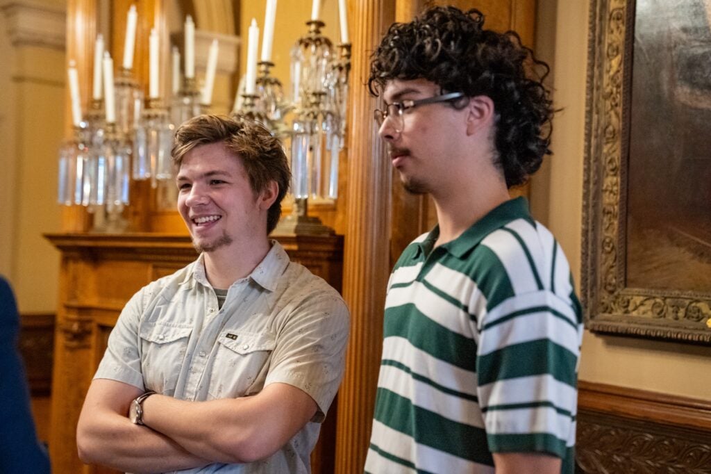 Two male students stand smiling