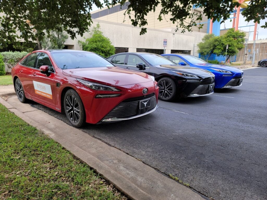 Three sedans parked in front of building.