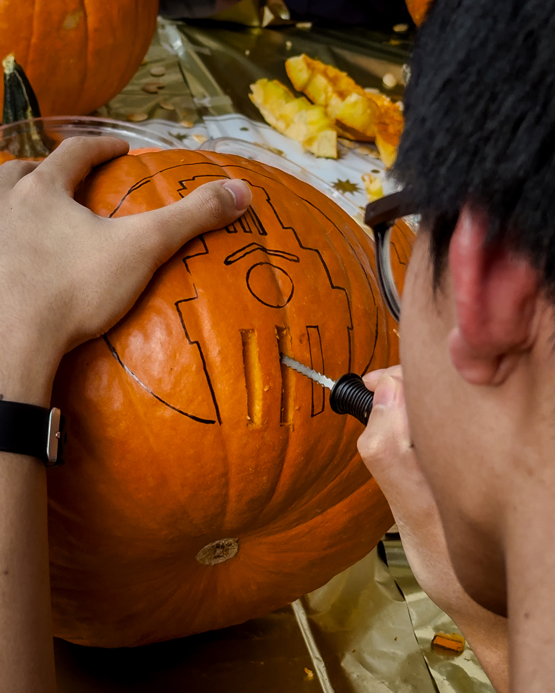 A U.T. Austin student carving a Longhorn themed jack-o’-lantern.