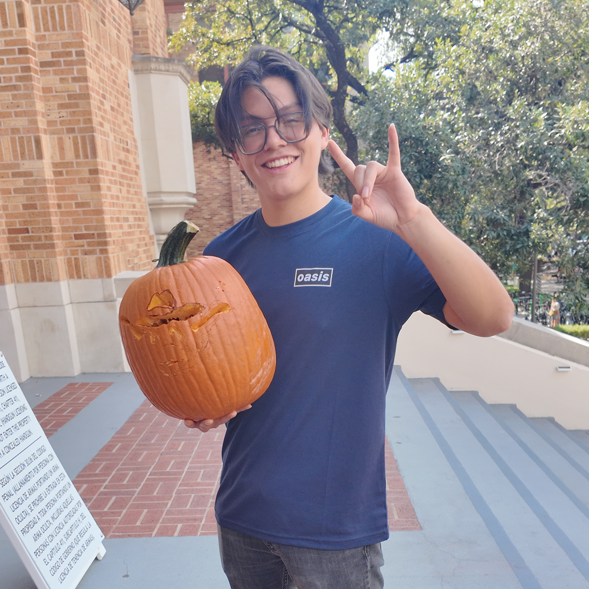 A student holding a carved pumpkin.