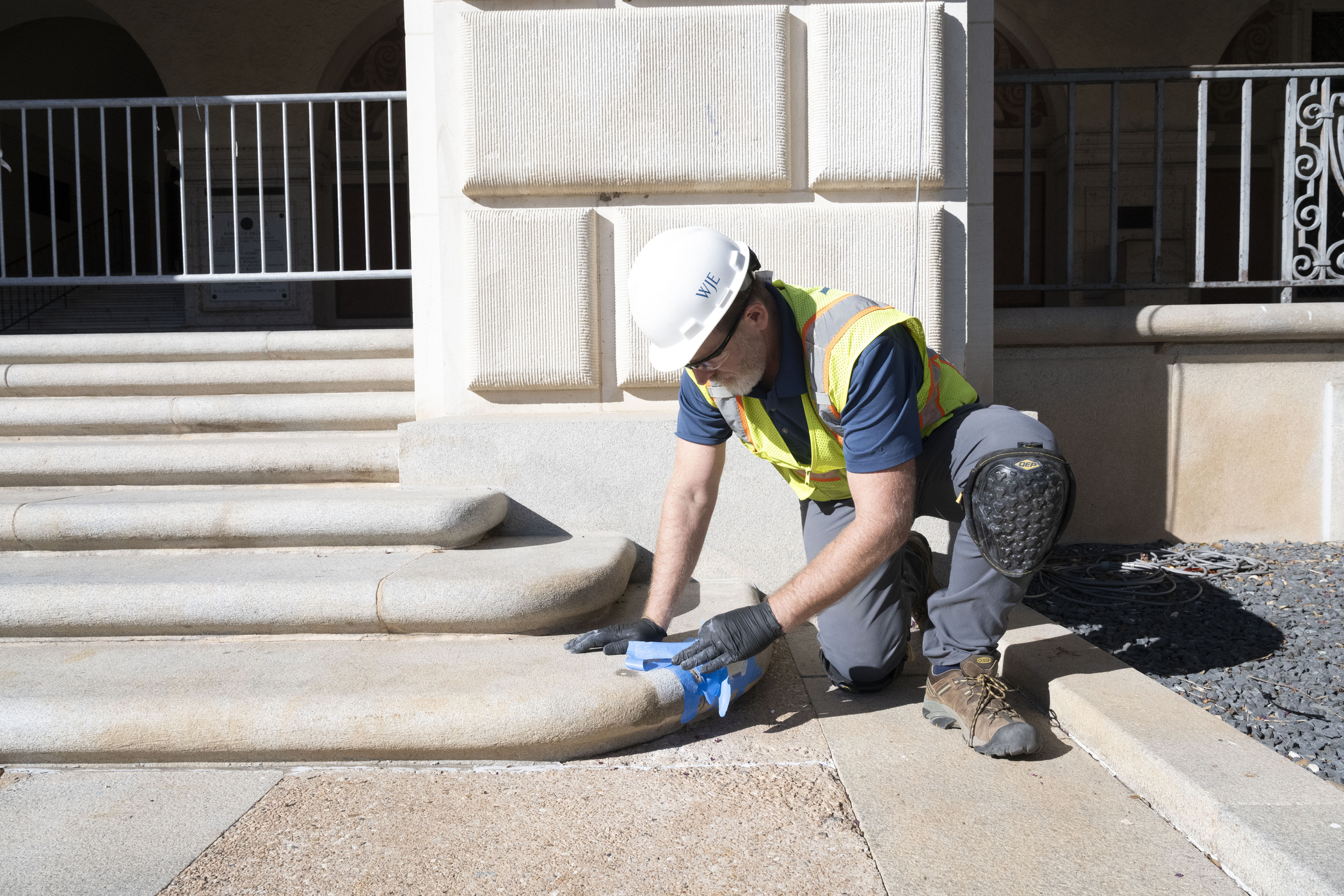 Man in hard hat cleans stone steps