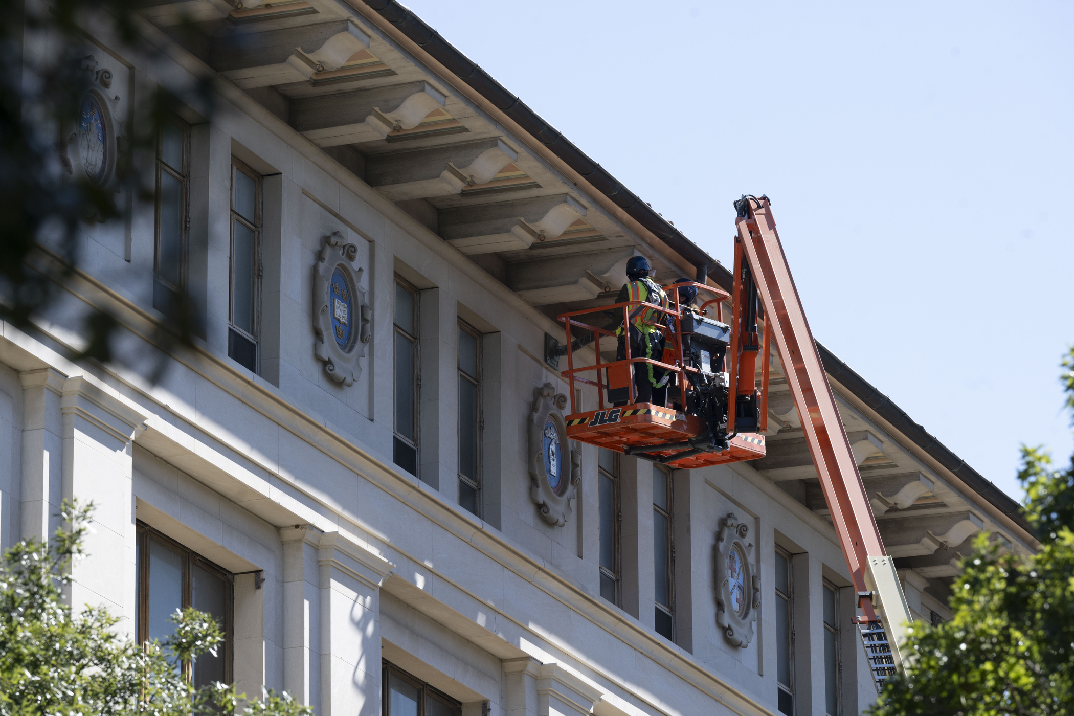 Worker in cherrypicker examines eaves