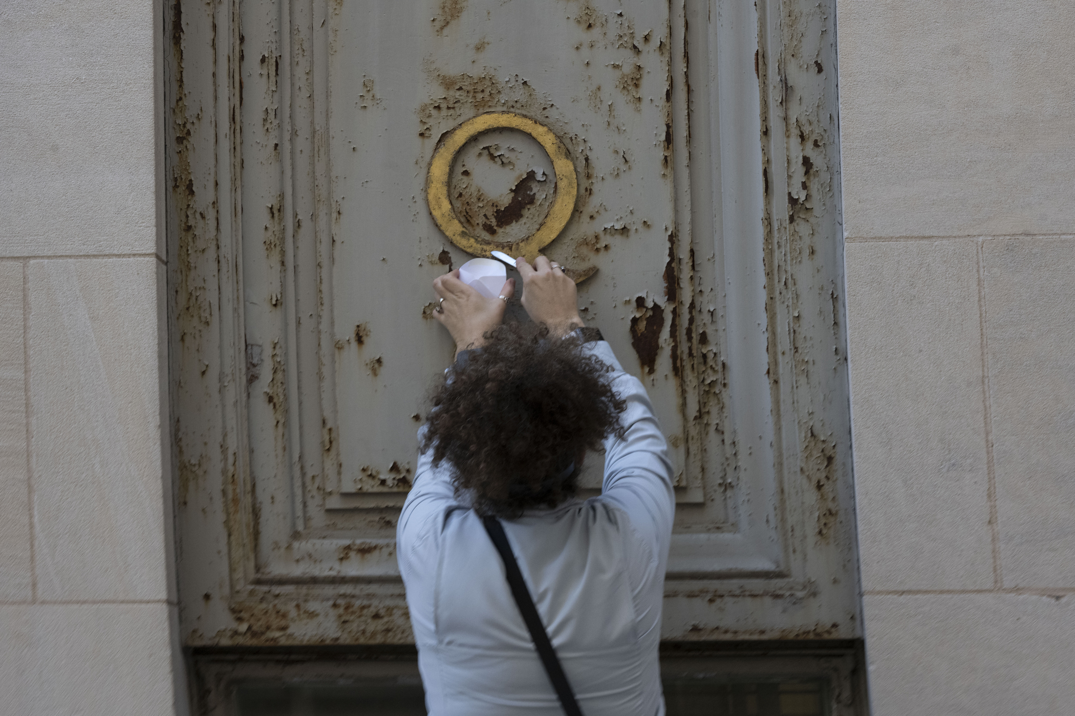Woman scrapes a sample of gold leaf into envelope