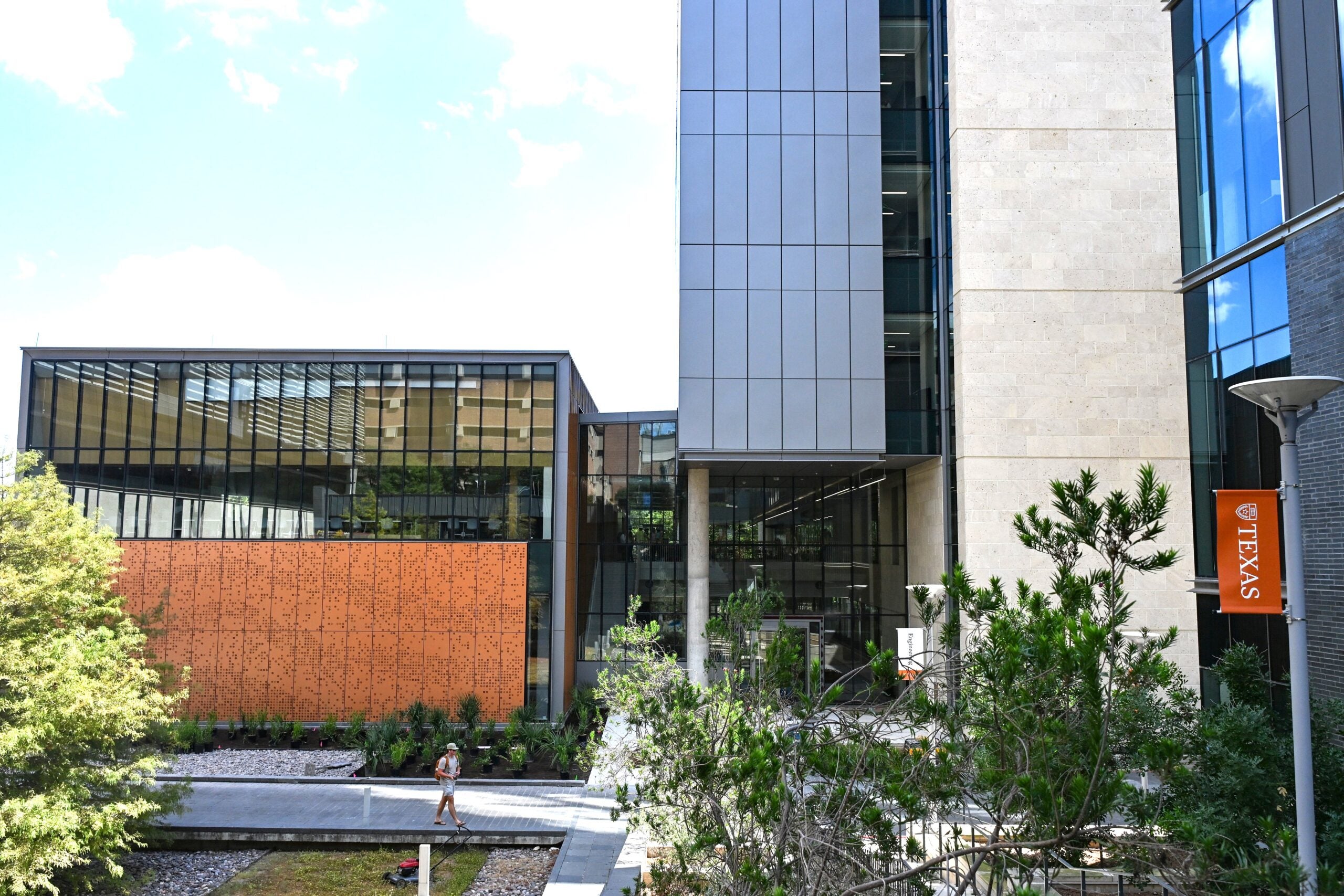 A building with orange accents sits between trees .