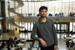 Man stands in foreground with windows in background