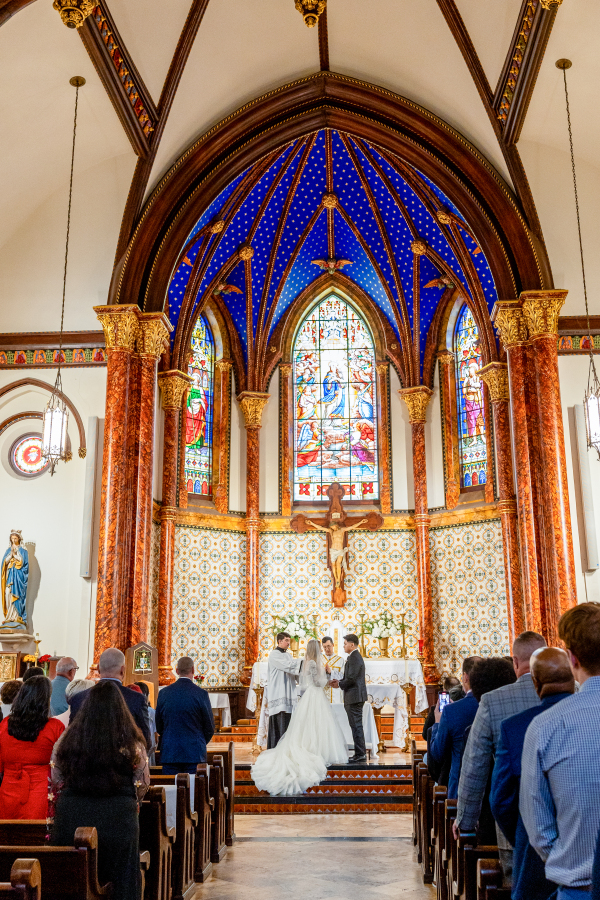Bride and groom stand together at alter