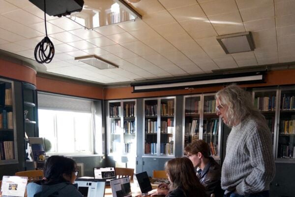 image of a professor with students in a library