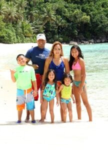 Parents with four children stand on beach
