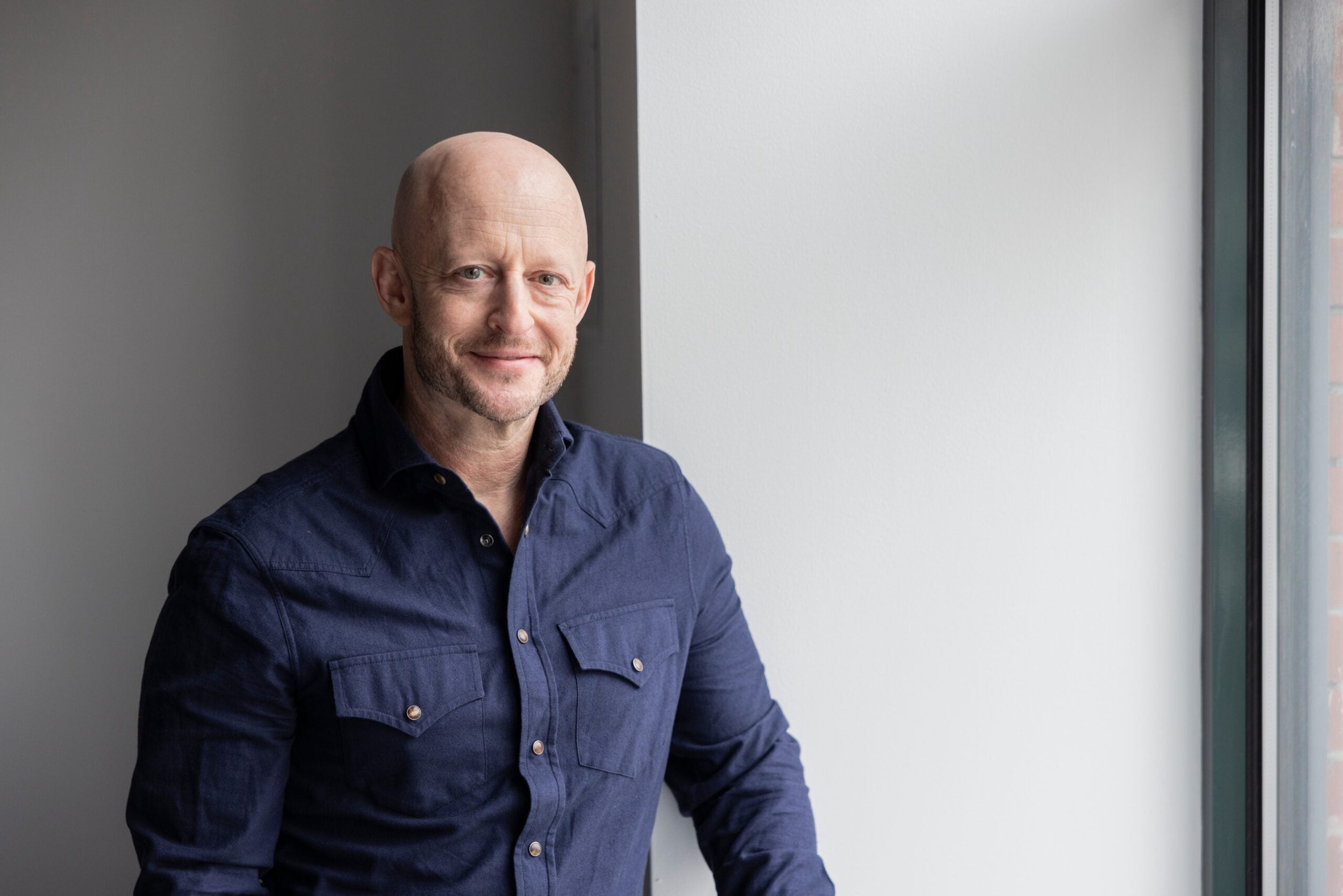 Man in navy shirt against gray wall