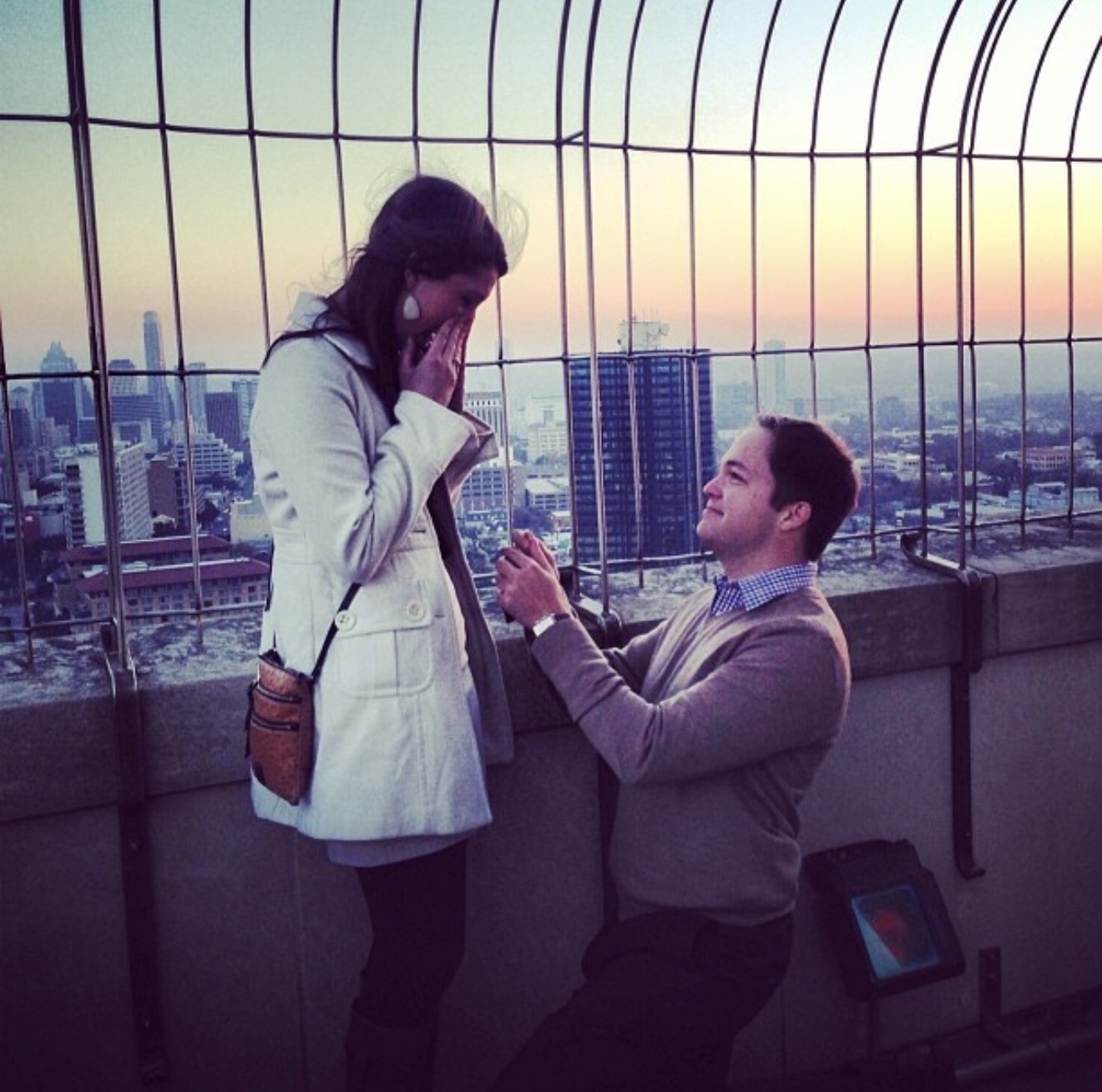 A man proposes to a woman at the top of the UT Tower.