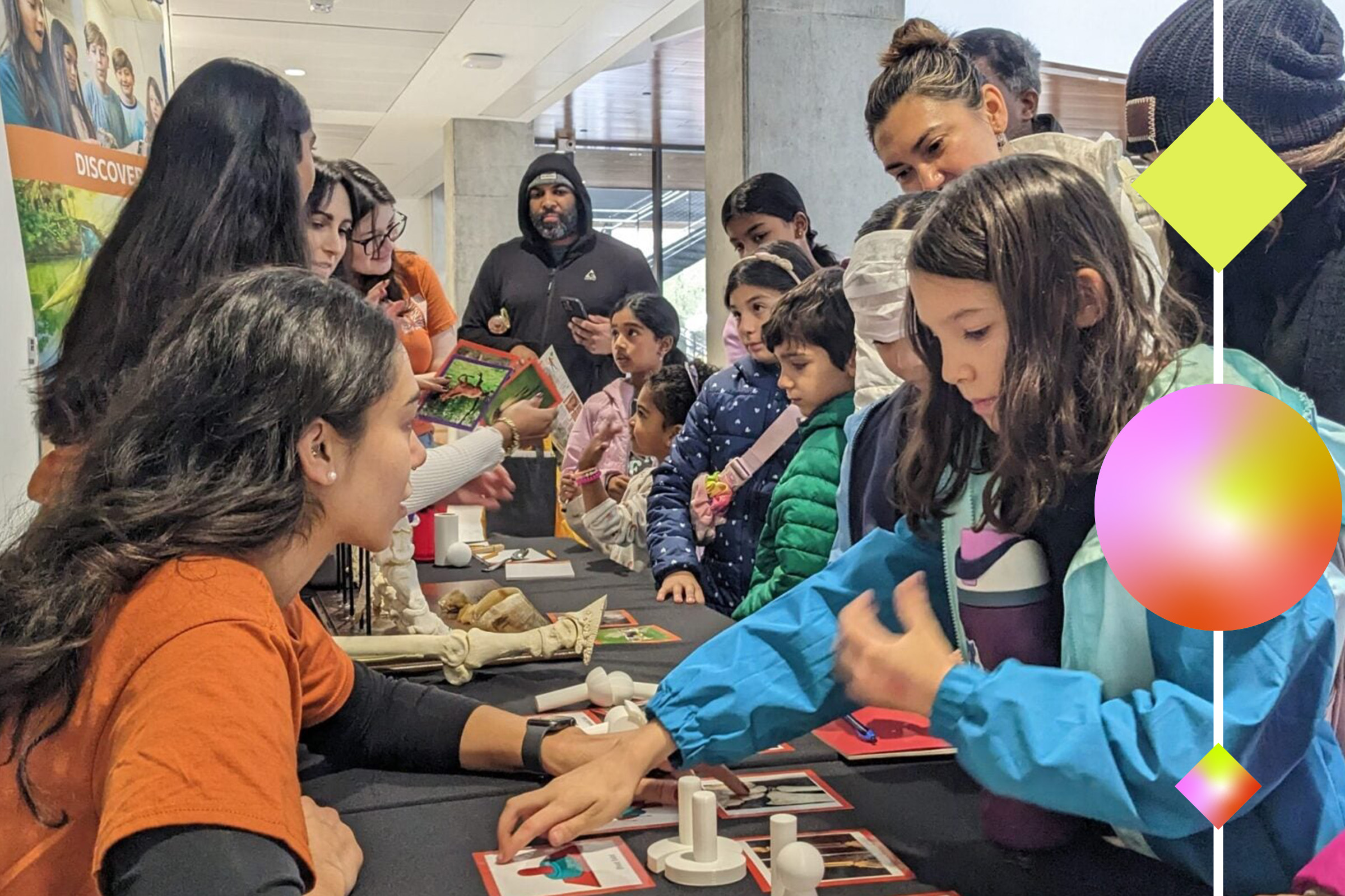 Children and parents gather at a table during an event.