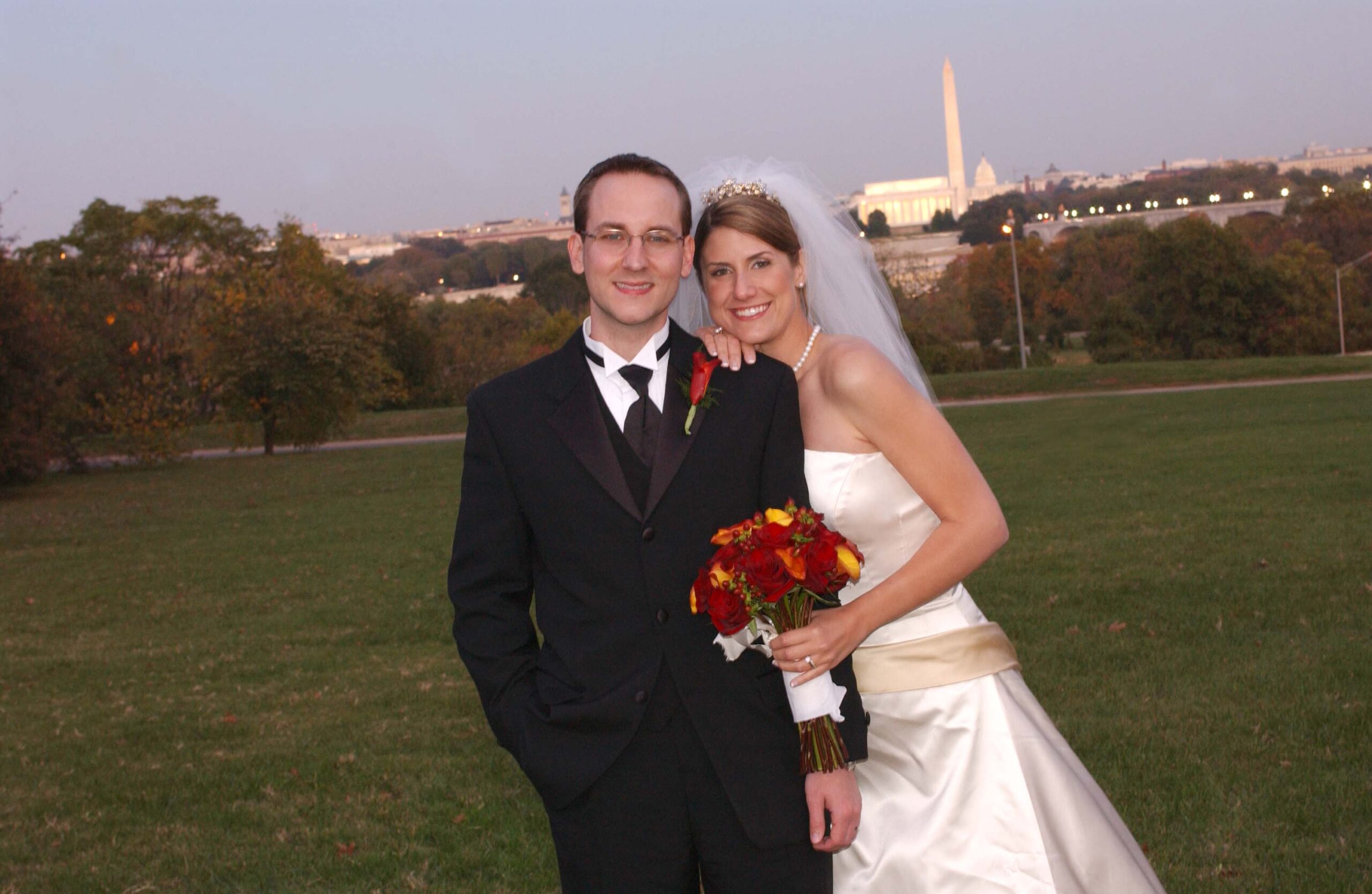 A bride and groom pose for a photo. Washington, D.C. monuments in the background.