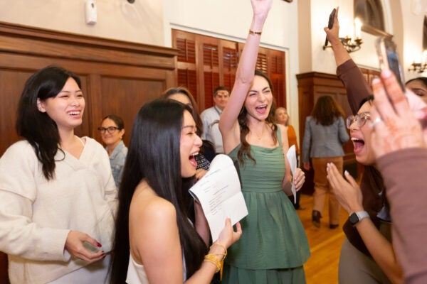Group of women hold up papers and celebrate