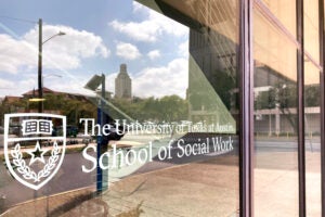 UT Austin's School of Social Work with the tower reflected in the window