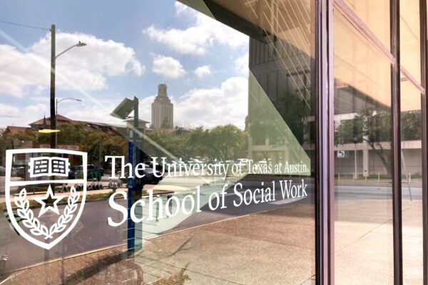 UT Austin's School of Social Work with the tower reflected in the window