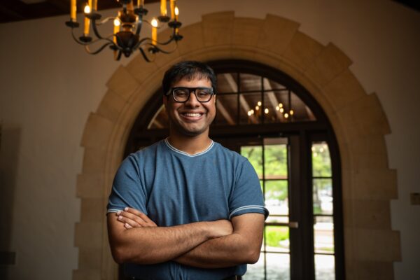 Man in blue shirt stands in doorframe.