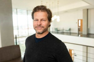 headshot of man wearing black sweater