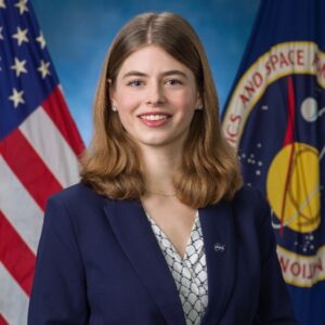 woman in blue jacket in front of flags