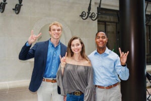 image of three law students holding up hook 'em