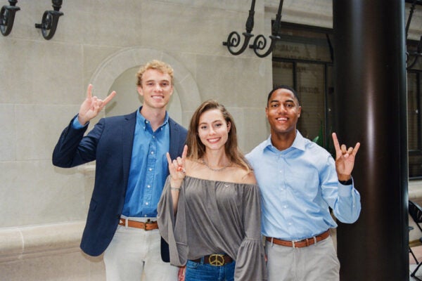 image of three law students holding up hook 'em