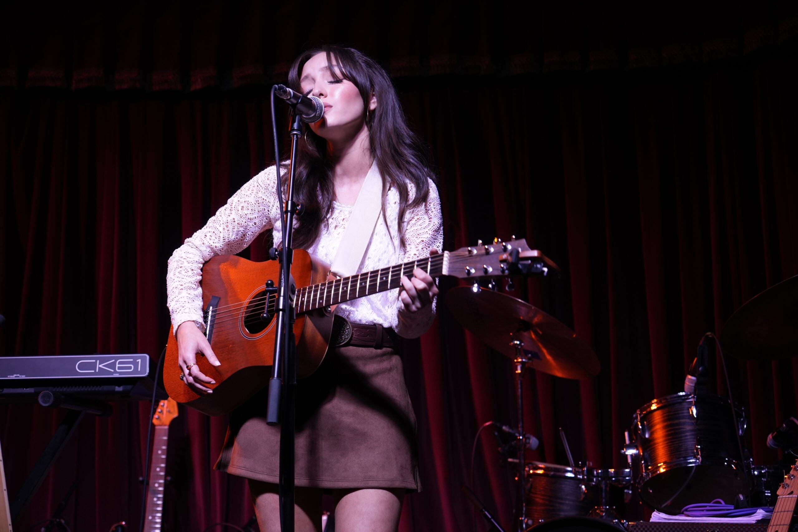 image of a singer on stage playing the guitar