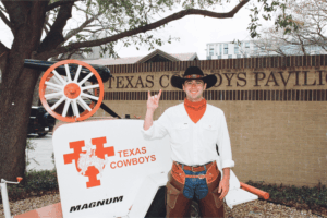 image of a student in Texas Cowboys gear doing a hook 'em sign