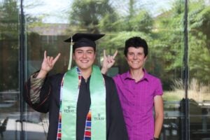 Graduate in cap and gown with faculty member