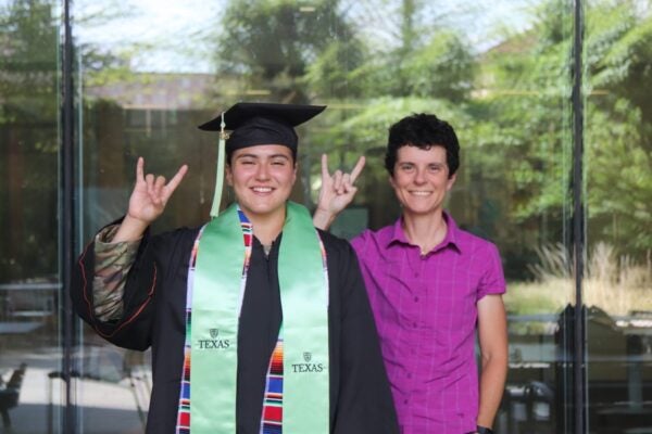 Graduate in cap and gown with faculty member