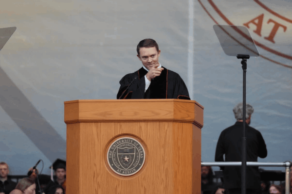 image of Colt McCoy at a podium pointing to the crowd