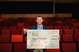 image of a man holding up a large check