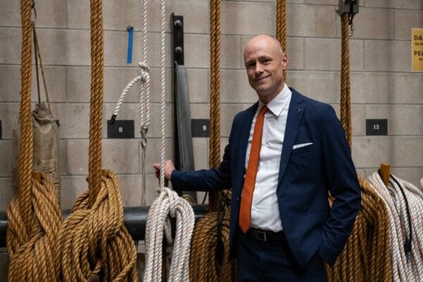 A man in a suit poses backstage at a theater