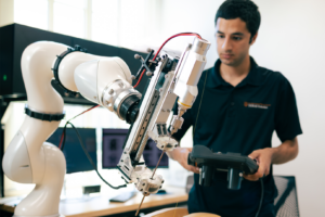 An researcher operates a robotic arm.