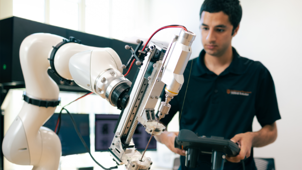 An researcher operates a robotic arm.