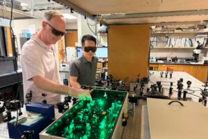 A pair of researchers work in their lab wearing protective goggles.