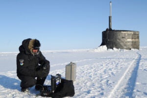 person working with a machine on the snow and ice