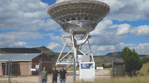 image of three people in front of a radio antenna