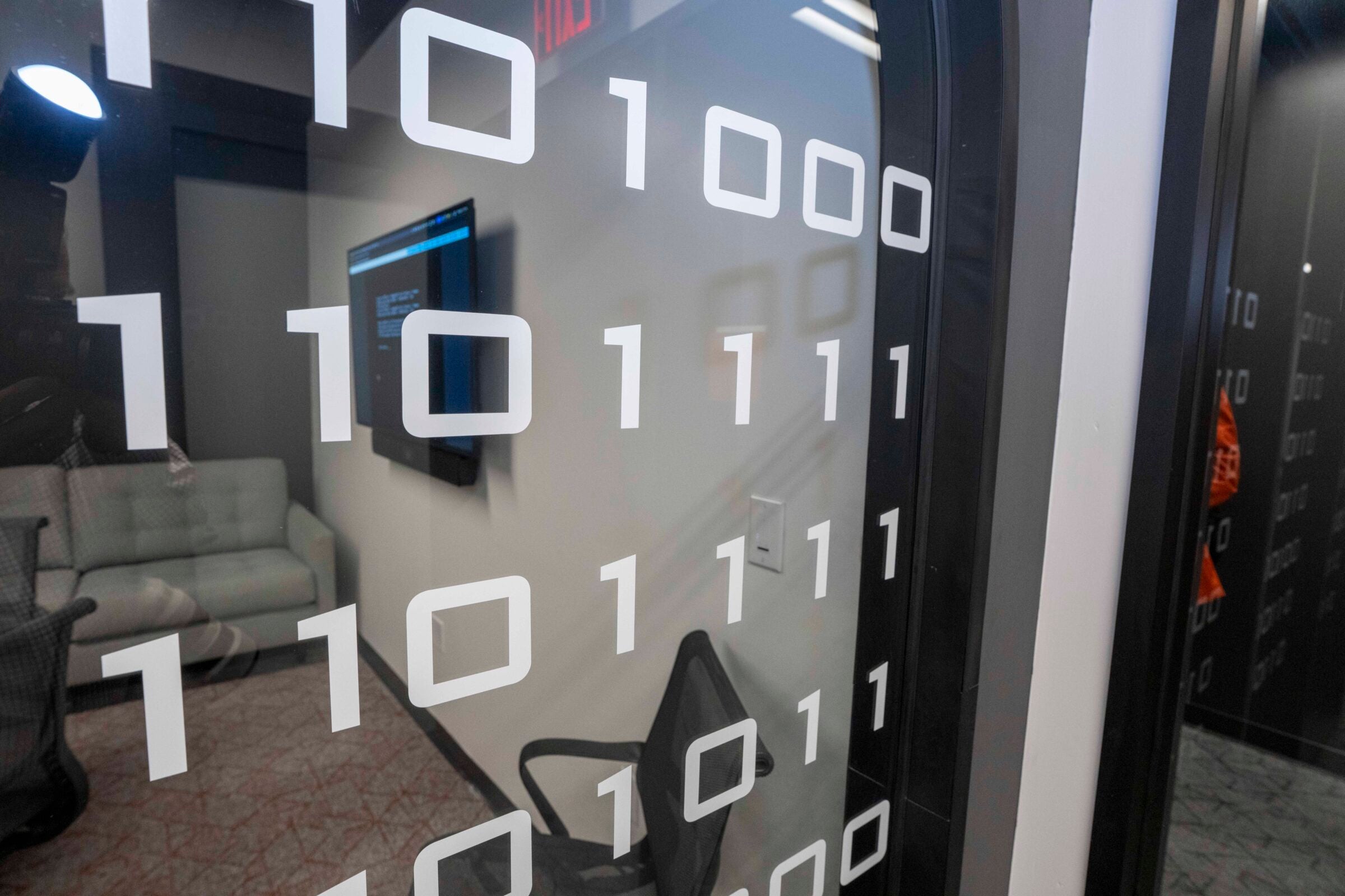 The binary code on the office walls translates to “Hook em.”