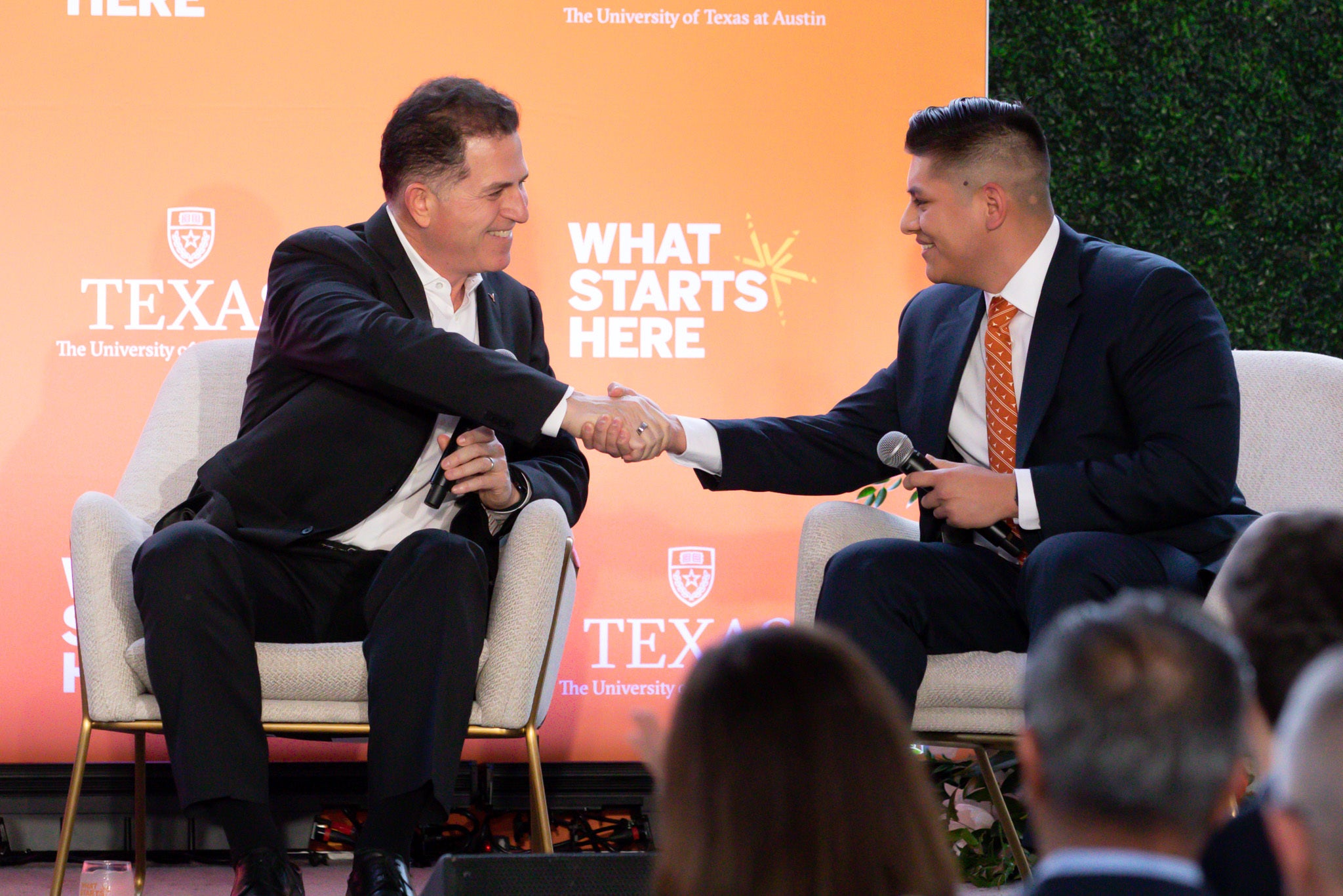 image of two people seated shaking hands