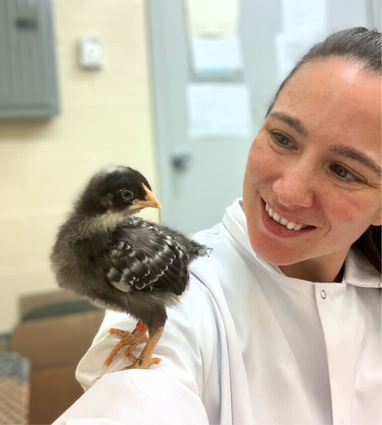 Shana with a small chick perched on her arm