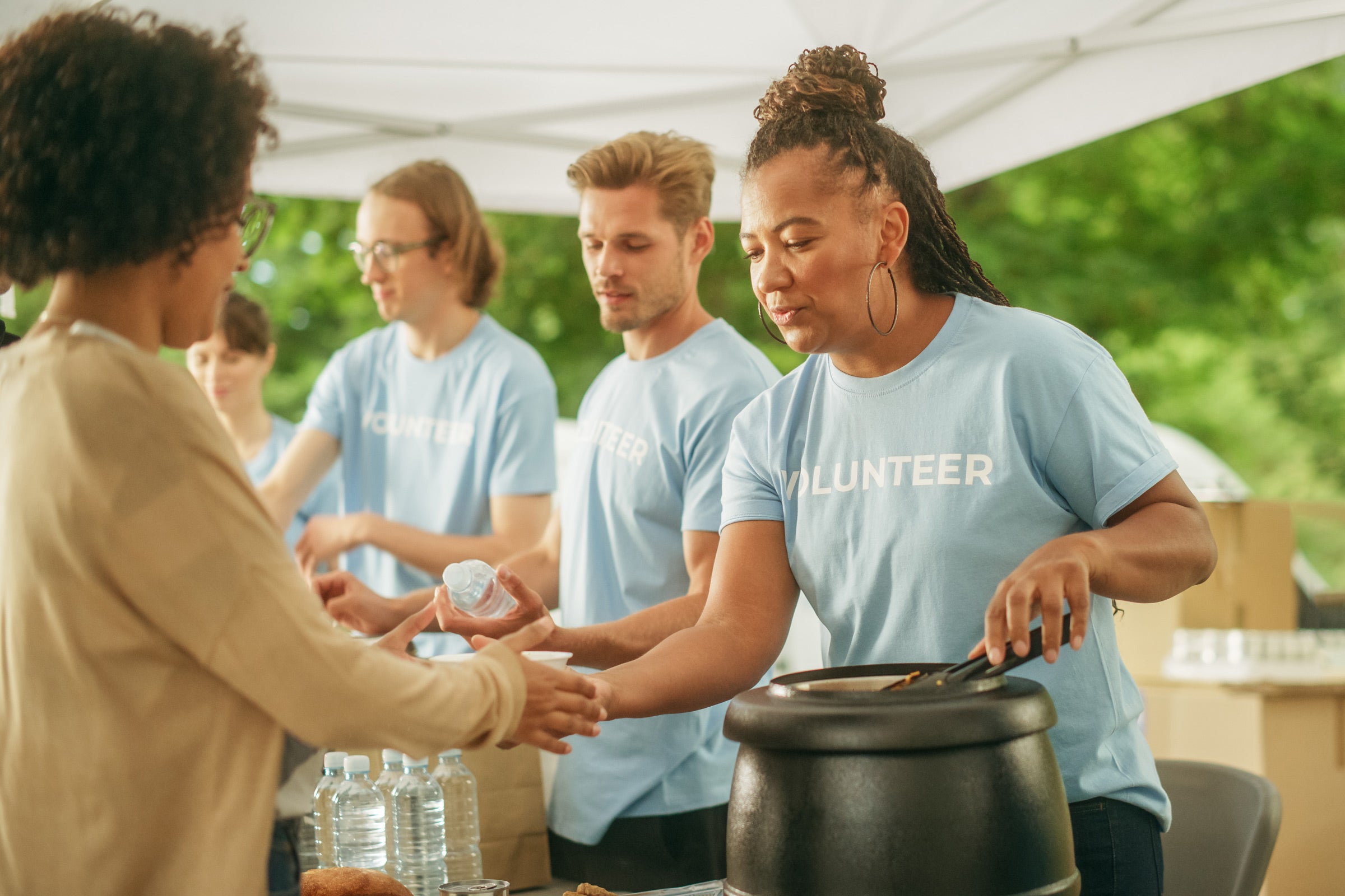 Volunteers serving food to guests at an event