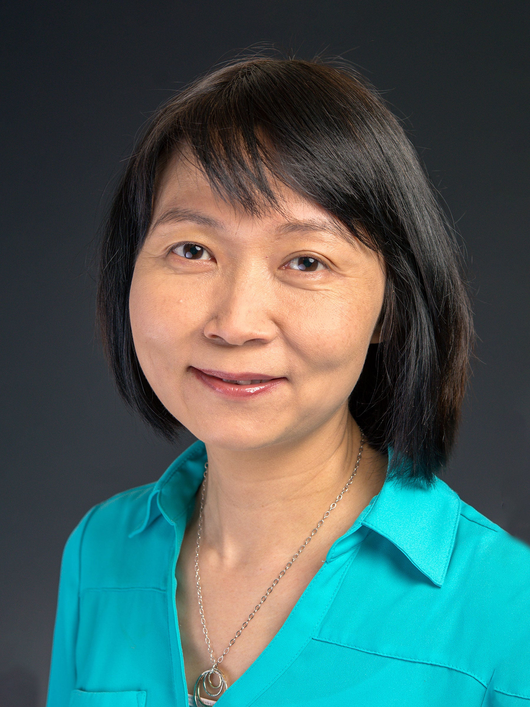 Portrait of a woman wearing a teal shirt.