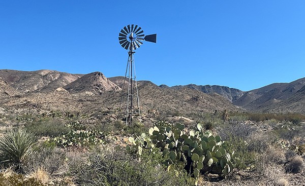 West Texas field station with cactus, windmill, and mountains in background