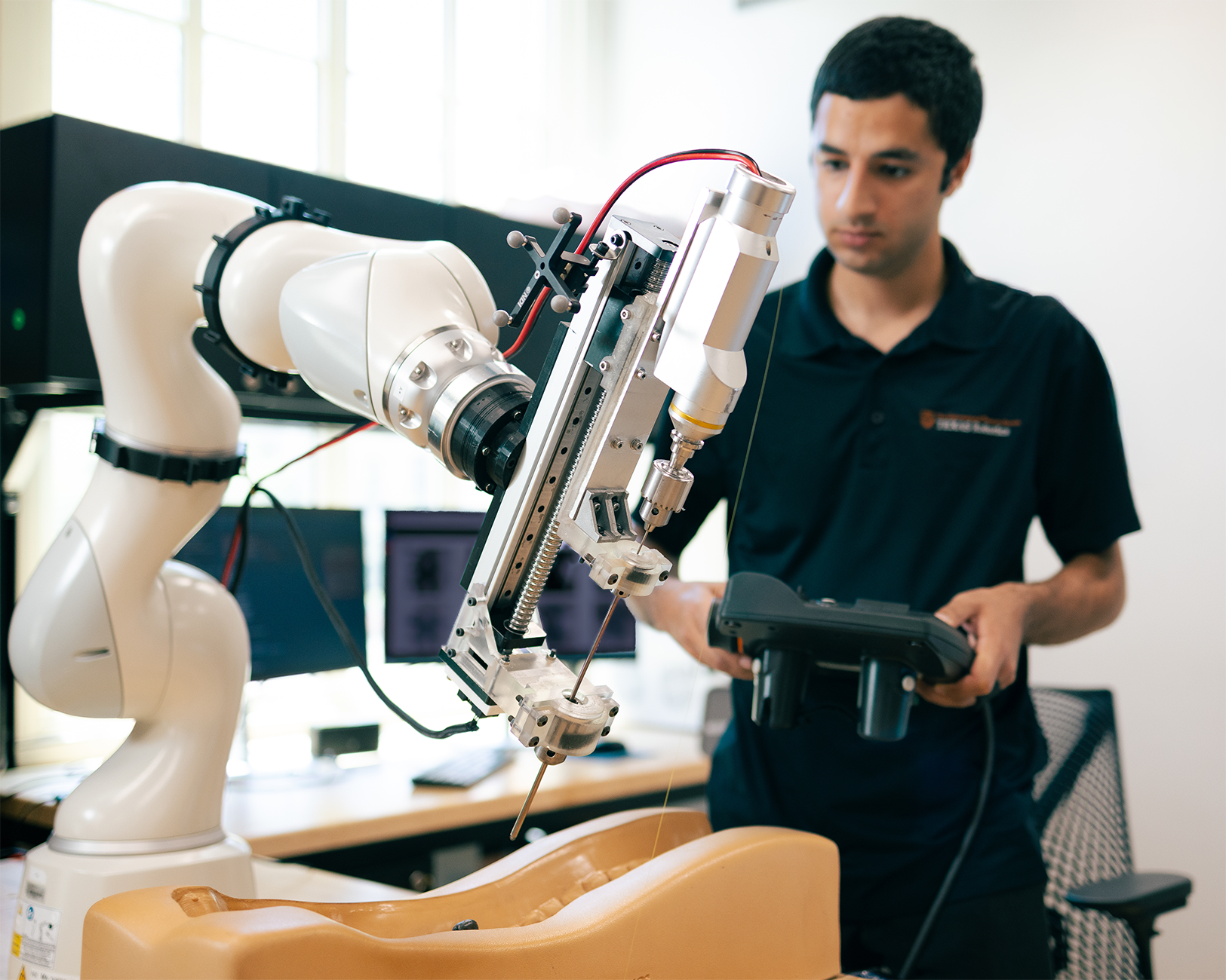 An researcher operates a robotic arm.
