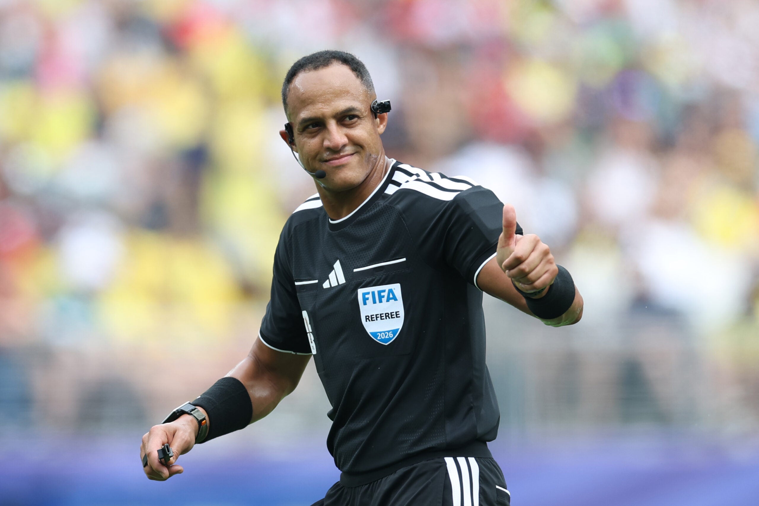 A FIFA referee gives a thumbs up during a 2026 World Cup soccer game.