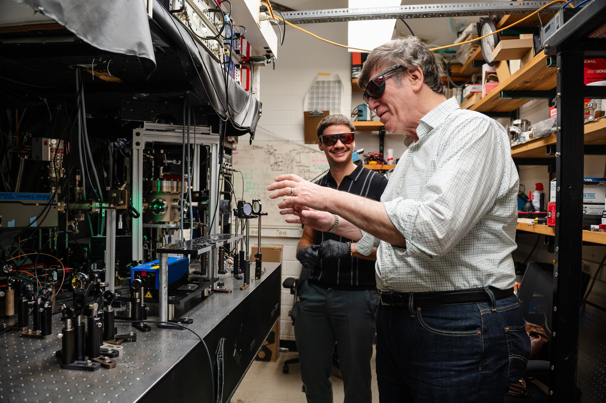 A pair of researchers wear protective glasses while working in their lab.
